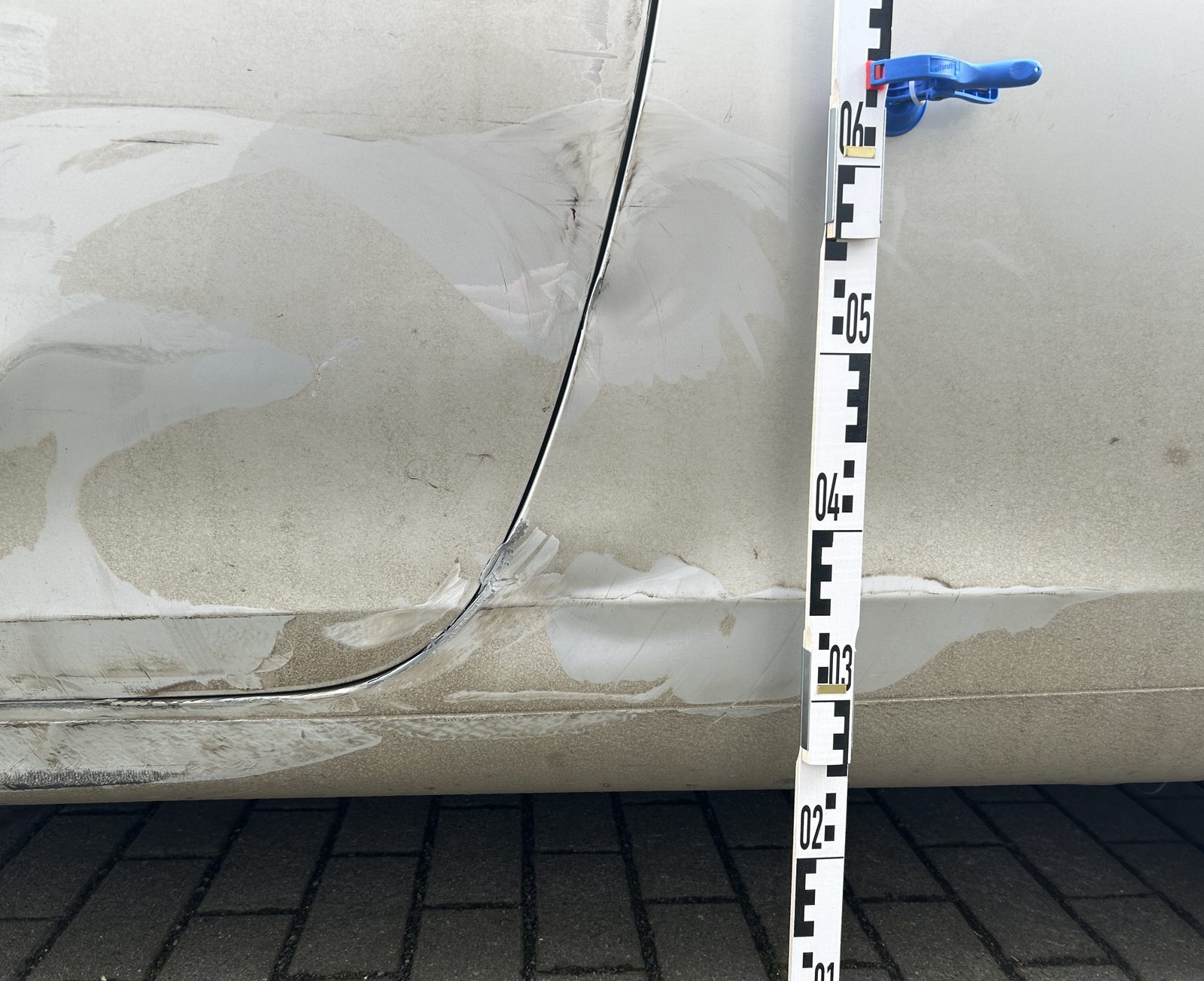 Beschädigter Schwellerbereich, daneben ein Messstab für die Höhenangabe